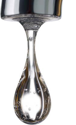 Close-up of a water droplet forming at the tip of a tap.